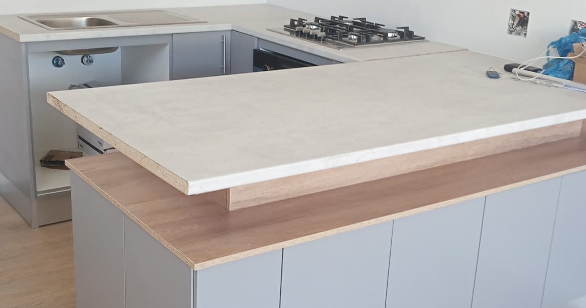 White kitchen cupboards and island counter fitted by CDC Projects