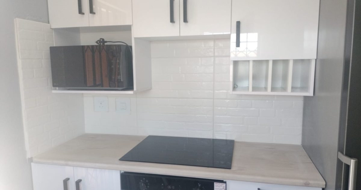 Built-in kitchen cupboards with microwave shelf and hob installed in a Cape Town home